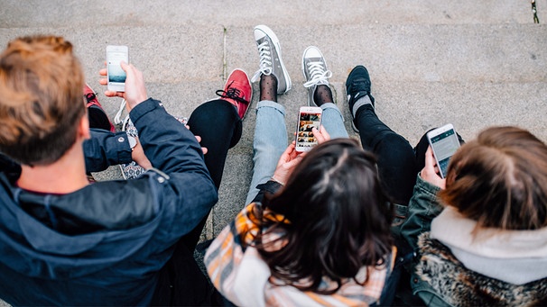 Jugendliche blicken auf ihr Handy: Soziale Medien beeinflussen unsere Meinungsbildung. | Bild: BR/Julia Müller