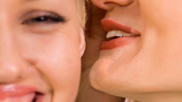 Eine Frau sagt einer anderen etwas ins Ohr. | Bild: colourbox.de