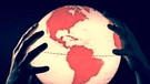 Hände halten einen Globus mit roten Kontinenten | Bild: pa/dpa/Klaus Ohlenschläger