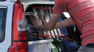 Mann packt Kofferraum eines Autos | Bild: picture-alliance/dpa