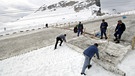 Männer legen Plastikfolie über Schnee | Bild: picture-alliance/dpa