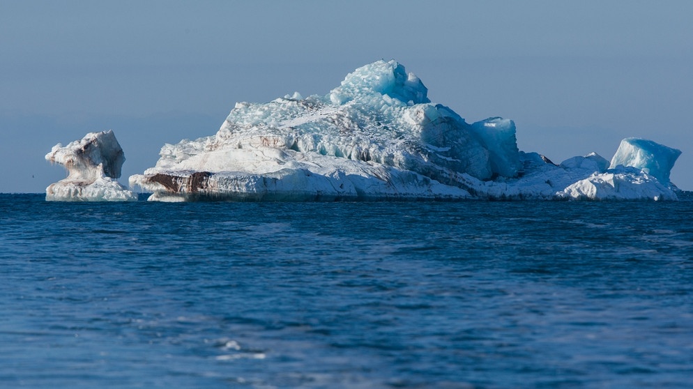 Ein Eisberg im arktischen Meer vor Spitzbergen. Das Abschmelzen der Polkappen durch den Klimawandel könnte den Meeresspiegel bedrohlich steigen lassen. Das "Ewige Eis" unserer Polkappen schmilzt: Am Nord- und Südpol macht sich der Klimawandel besonders bemerkbar. Könnten Arktis und Antarktis im Sommer bald eisfrei sein und was sind die Folgen, wenn große Mengen an Eis schmelzen? | Bild: picture-alliance/dpa