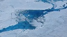 Ein Schmelzwassersee auf einem Gletscher in Grönland im Juli 2012. Das Schmelzwasser frisst sich ins Eis und beschleunigt damit das Abschmelzen der Gletscher in der Antarktis. | Bild: Marco Tedesco / dpa