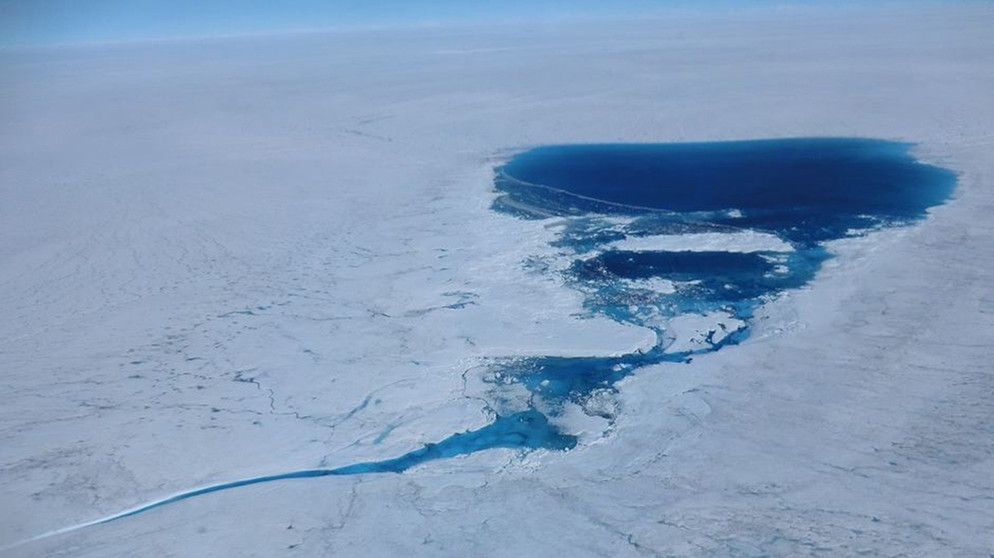 Ein Schmelzwassersee auf einem Gletscher in Grönland im Juli 2012. Das Schmelzwasser frisst sich ins Eis und beschleunigt damit das Abschmelzen der Gletscher in der Antarktis. Das "Ewige Eis" unserer Polkappen schmilzt: Am Nord- und Südpol macht sich der Klimawandel besonders bemerkbar. Könnten Arktis und Antarktis im Sommer bald eisfrei sein und was sind die Folgen, wenn große Mengen an Eis schmelzen? | Bild: Marco Tedesco / dpa
