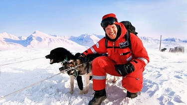 Alexander Gerst macht eine Expedition in die Arktis, um zu verstehen, warum sie als Epizentrum des Klimawandels gilt. Auf dem Foto ist er dick eingepackt im Eis mit einem Schlittenhund zu sehen. | Bild: SWR