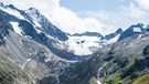 Der Alpeiner Ferner in den Stubaier Alpen in Österreich im Sommer 2019 und im Vergleich dazu auf einer Aufnahme um 1935. Im direkten Vergleich wird deutlich, wie stark die Schmelze bei dem Gletscher durch den Klimawandel ist. Seit 1850 hat der Gletscher etwa 2,5 Kilometer an Länge verloren. | Bild: Simon Schöpf, österreichischer Alpenverein