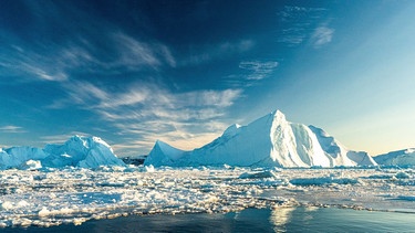 Das Bild zeigt Eisberge nahe von Grönland. Vor allem die arktischen Regionen sind vom Klimawandel jetzt schon stärker betroffen als niedrigere Breitengrade.  | Bild: picture alliance / NurPhoto | Ulrik Pedersen