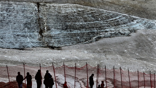 Touristen vor den Resten des Schneeferner Gletschers im Sommer 2014 | Bild: picture-alliance/dpa