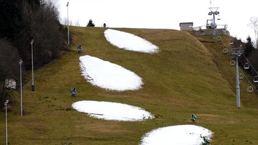 Slalompiste in Garmisch im Dezember 2014. Auch in der Skisaison 2014/15 kam der Schnee erst spät nach Bayern - ab Ende Januar. Ein Fortschreiten des Klimawandels wird nicht nur natürlichen Schneefall in Bayern immer mehr begrenzen. Auch künstliche Beschneiung ist nur möglich, wenn es kalt genug ist. | Bild: picture-alliance/dpa