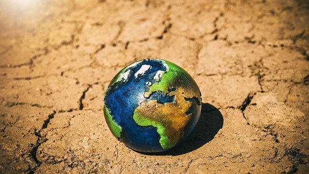 Globus auf Wüstenboden; die Erderwärmung verschiebt sogar die Klimazonen auf der Welt | Bild: picture alliance / CHROMORANGE | Christian Ohde