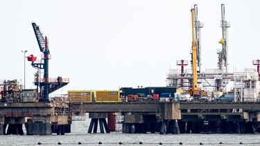 Technische Anlagen und ein Kran stehen auf dem Anleger für das LNG-Terminal in der Nordsee vor Wilhelmshaven. Der erste Anleger für Flüssigerdgas (LNG) in Deutschland ist im November fertiggestellt worden.  | Bild: picture alliance / Hauke-Christian Dittrich