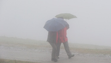 Wanderer im Sprühregen und Nebel. Aber wie entsteht Regen eigentlich, und was ist der Unterschied zu Niederschlag, Nieselregen und Graupel? Warum klappt es mit der Wettervorhersage für Regen oft nicht gut? | Bild: picture-alliance/dpa