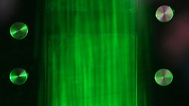 Eine Wolke leuchtet grün im Windkanal des Wolkenlabors Leibniz-Institut für Troposphärenforschung in Leipzig | Bild: dpa-Bildfunk/Hendrik Schmidt