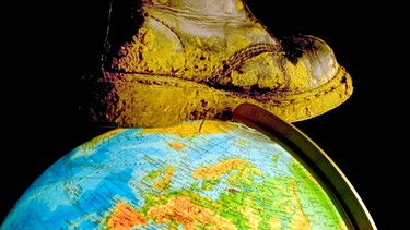 Ein Stiefel steht auf einem Globus. Der Club of Rome möchte nicht, dass die Erde mit Füßen getreten wird. Er setzt sich für die Zukunft des Planeten ein. Experten rufen zu Nachhaltigkeit auf. | Bild: picture-alliance/dpa/blickwinkel