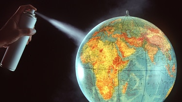 Eine Frau sprüht Deodorant auf eine Weltkugel. Seit Jahrzehnten beobachten Forscher ein Loch über der Antarktis: das Ozonloch. Nach dem Verbot von FCKW schien es zunächst, als ob die Ozonschicht heile. Doch es gibt auch Rückschläge. Schuld daran ist der Klimawandel. | Bild: picture-alliance/dpa