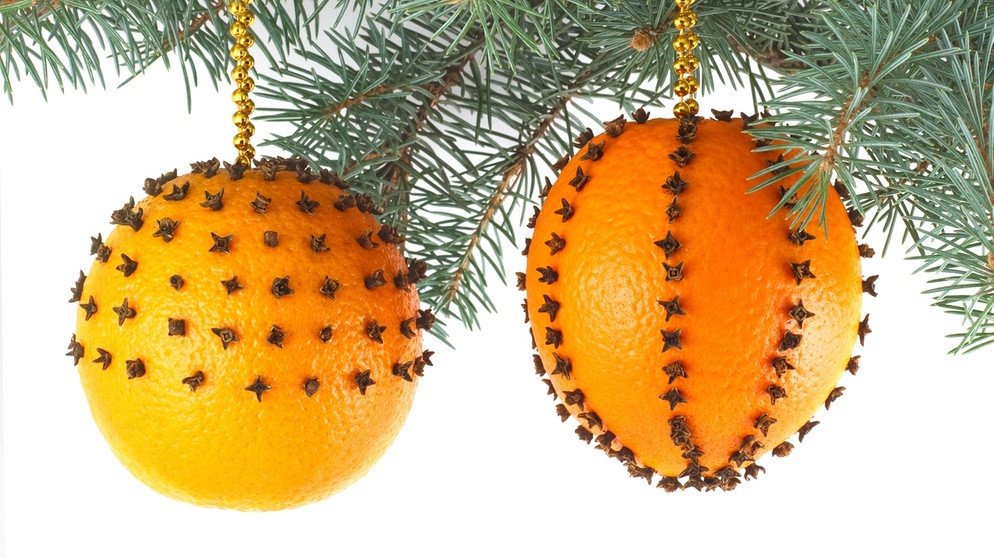 Orangen sind mit Nelken bespickt und hängen an einem Weihnachtsbaum. Weihnachtsbaum, Plätzchen, Braten und Geschenkpapier sind oft wenig umweltfreundlich. Wie ihr mit einfachen Tipps und Tricks ressourcenschonende und trotzdem schöne Weihnachten feiern könnt. | Bild: colourbox.com