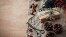 Ein Geschenk liegt auf einem Leinenpapier. Stoffreste wie Leine oder auch Wolle sind umweltfreundlicher als Geschenkpapier. | Bild: colourbox.com