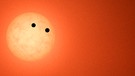 Trappist 1 ist ein Sternsystem, von dem Astronomen wissen, dass mehrere Exoplaneten den Zentralstern umrunden. In einigen tausend Jahren könnte die Erde von dort aus sichtbar sein, wenn sie - von dem Sternsystem Trappist 1 aus gesehen - an der Sonne vorüberzieht. Dann sind die geometrischen Bedingungen im Weltraum günstig.  | Bild: NASA/JPL-Caltech/R. Hurt (IPAC)