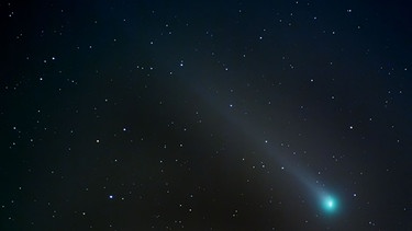 Die Koma eines Kometen mag grünlich leuchten, niemals aber sein Schweif. Dafür verantwortlich sind Dikohlenstoff-Moleküle, die ihrerseits von der energiereichen Sonneneinstrahlung zersetzt werden, bevor sie den Schweif des Kometen erreichen können.  | Bild: picture alliance / dpa | Henning Kaiser