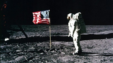 Buzz Aldrin mit Flagge auf dem Mond. 1969 betrat Neil Armstrong als erster Mensch seine Oberfläche. Alle Apollo-Missionen, dem Erfolgsprogramm der NASA, im Überblick findet ihr hier. | Bild: picture-alliance/dpa