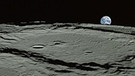 Mondaufnahme der japanischen Sonde Kaguya auf die untergehende Erde. Zigtausende Krater auf seiner Oberfläche zeugen von dem Bombardement, dem unser Mond beständig ausgesetzt ist. Der größte Krater misst mehr als 2.000 Kilometer, die kleinsten müsst ihr mit der Lupe suchen. | Bild: JAXA