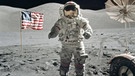 Gene Cernan, Kommandant der Apollo 17 im Dezember 1972, auf dem Mond, flankiert von amerikanischer Flagge und Mondfahrzeug. | Bild: picture alliance/ZUMA Press