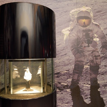 Im Rieskratermuseum ist neben der Aufnahme eines Astronauten auf dem Mond ein Stück Mondgesteim in einer Vitrine ausgestellt. | Bild: picture-alliance/dpa