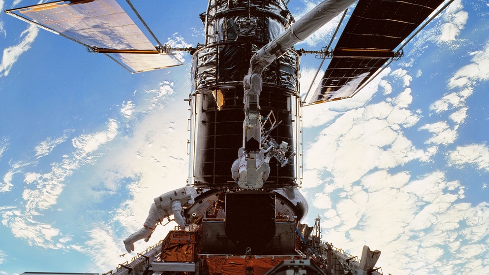 Während einer Servicemission im Jahr 1999 wird das Hubble-Weltraumteleskop von zwei Astronauten gewartet und für ein neues Jahrzehnt an astronomischen Beobachtungen fit gemacht. Die letzte Servicemission fand im Jahr 2009 statt.  | Bild: NASA