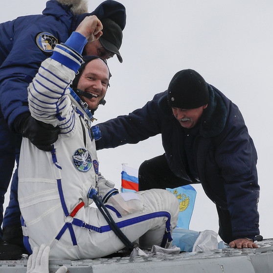 Helfer ziehen Alexander Gerst nach der Landung aus der Sojus-Raumkapsel. Über drei Stunden war der deutsche Astronaut in der Sojus von der Internationalen Raumstation (ISS) zur Erde unterwegs.  | Bild: dpa-Bildfunk/Shamil Zhumatov