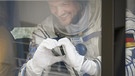 Alexander Gerst formt mit seinen Händen ein Herz an Bord des Busses, der den deutschen Astronauten zur Startrampe bringt. | Bild: dpa-Bildfunk/Shamil Zhumatov