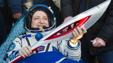 Der russische Kosmonaut Fjodor Yurchikhin, ISS-Besatzungsmitglied, hält im November 2013 die Fackel der Olympischen Winterspiele 2014 in Sotschi nach der Landung in Kasachstan. | Bild: Reuters (RNSP)