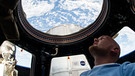 Der deutsche Astronaut Alexander Gerst schaut aus dem ISS-Ausguck ins Weltall und auf die Erde. | Bild: picture alliance/dpa
