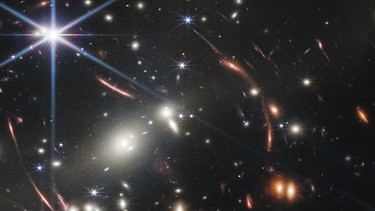 Das erste Bild des James Webb-Weltraumteleskops (JWST) wurde im Juli 2022 der Öffentlichkeit vorgestellt: Es zeigt den Galaxienhaufen SMACS 0723. Sein Licht benötigte rund 4,6 Milliarden Jahre, bis es den Teleskopspiegel des JWST erreichte.  | Bild: NASA, ESA, CSA, and STScI