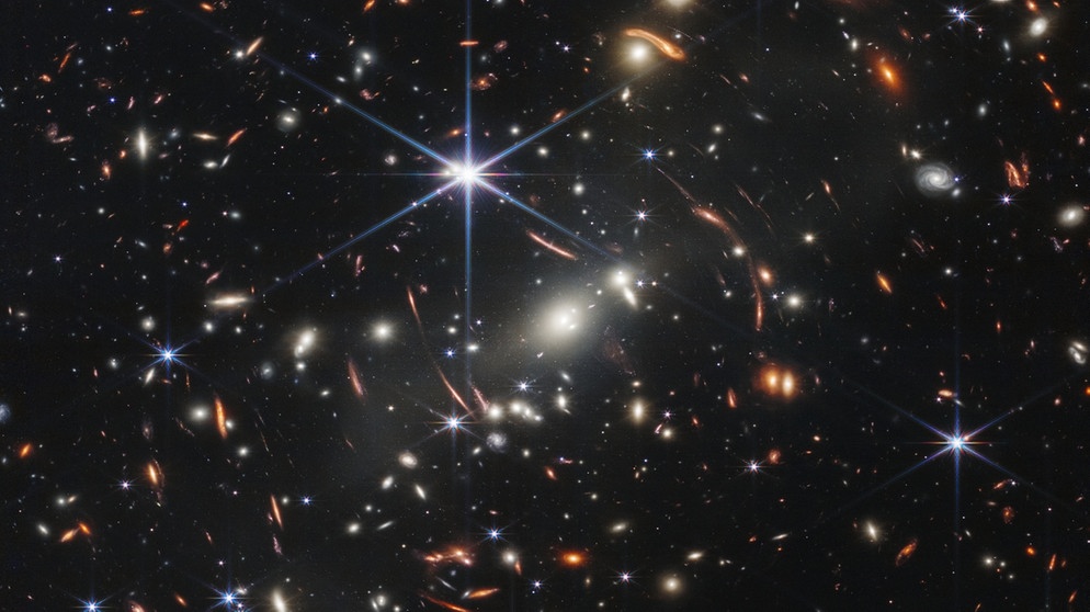 Das erste Bild des James Webb-Weltraumteleskops (JWST) wurde im Juli 2022 der Öffentlichkeit vorgestellt: Es zeigt den Galaxienhaufen SMACS 0723. Sein Licht benötigte rund 4,6 Milliarden Jahre, bis es den Teleskopspiegel des JWST erreichte.  | Bild: NASA, ESA, CSA, and STScI