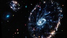 Die Wagenrad-Galaxie schaut aus wie, nun ja, ein Wagenrad. Sie befindet sich rund 500 Millionen Lichtjahre von der Erde entfernt und wurde bereits vom Hubble-Weltraumteleskop aufgenommen. Mit dem James Webb-Weltraumteleskop werden nun neue Details sichtbar.  | Bild: NASA, ESA, CSA, STScI