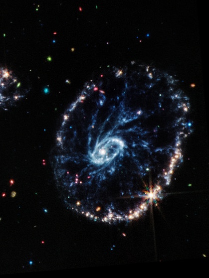Die Wagenrad-Galaxie schaut aus wie, nun ja, ein Wagenrad. Sie befindet sich rund 500 Millionen Lichtjahre von der Erde entfernt und wurde bereits vom Hubble-Weltraumteleskop aufgenommen. Mit dem James Webb-Weltraumteleskop werden nun neue Details sichtbar.  | Bild: NASA, ESA, CSA, STScI