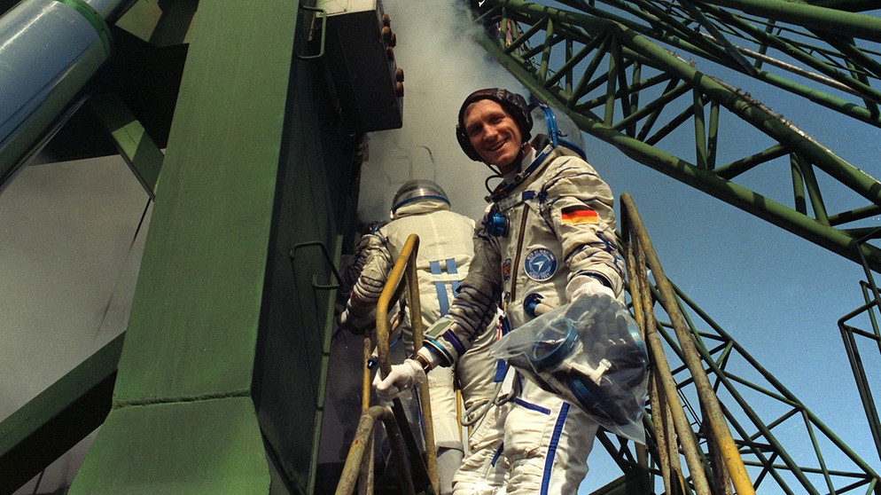 Am 17. März 1992 startete Flade für sieben Tage in den Orbit. Mit an Bord war neben seinen Kollegen noch ein weiterer Gast: Die Maus aus der "Sendung mit der Maus" begleitete die Kosmonauten mit auf ihre Mission. Ausgestattet mit einem silbernen Raumanzug schwebte sie durch die russische Raumstation Mir. Per Liveschaltung erreichte das Ereignis die Zuschauer auf der Erde. Er war vor Alexander Gerst und Matthias Maurer einer der deutschen Astronauten im Weltall. | Bild: picture-alliance/dpa