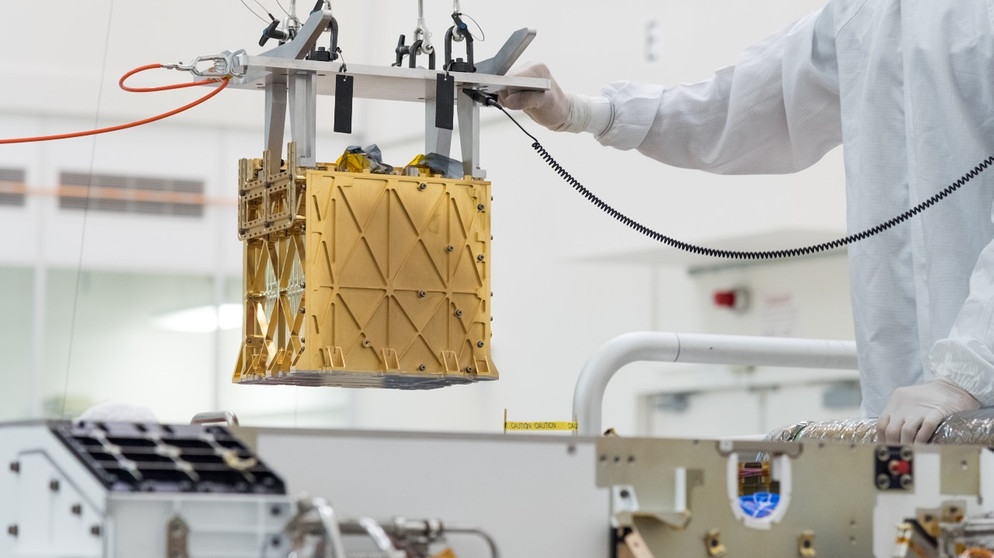 Techniker am Jet Propulsion Laboratory der NASA senken das MOXIE-Instrument zur Erzeugung von Sauerstoff in den Mars-Rover Perseverance | Bild: NASA/JPL-Caltech