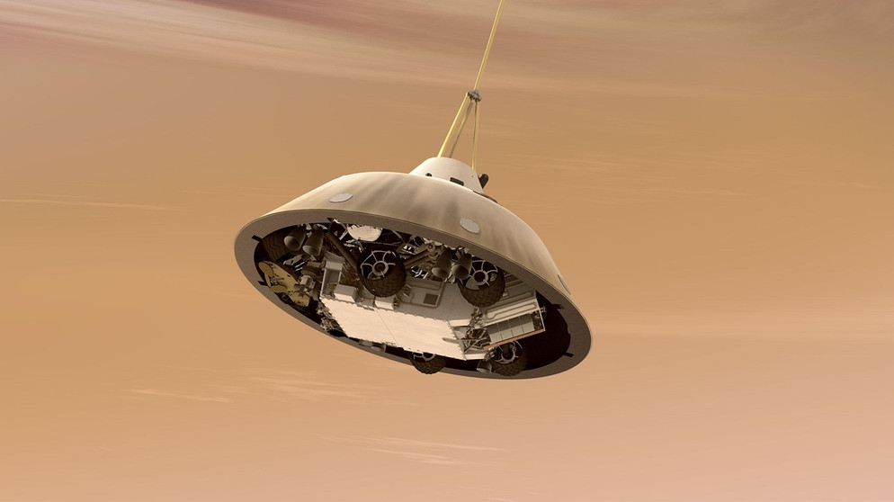 Illustration: Der Fallschirm lässt Kapsel und Inhalt sanft zu Boden schweben. Curiosity, der Mars-Rover der NASA, soll sicher landen. | Bild: NASA