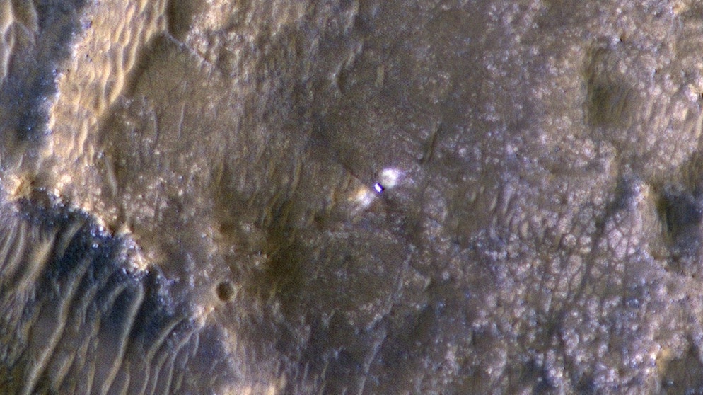 Der Mars-Rover Perseverance auf der Marsoberfläche: Diese Aufnahme aus der Umlaufbahn des roten Planeten hat die NASA-Sonde Mars Reconnaissance Orbiter MRO gemacht. Alle paar Tage passiert diese Sonde in der Umlaufbahn das Stückchen Marsoberfläche, wo sich Perseverance befindet - eine perfekte Gelegenheit, um den Rover aus der Höhe zu beobachten.  | Bild: NASA/JPL-Caltech/University of Arizona