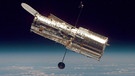 Das Weltraumteleskop Hubble, im Hintergrund der Erdball zu sehen. | Bild: NASA