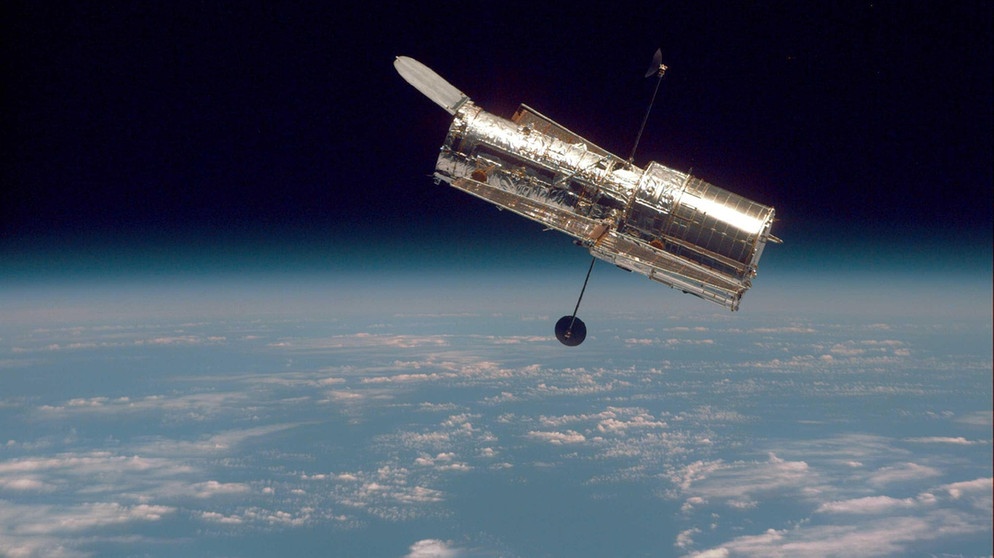 Das Weltraumteleskop Hubble, im Hintergrund der Erdball zu sehen. | Bild: NASA
