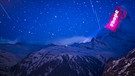 Der Schweizer Lichtkünstler Gerry Hofstetter illuminierte das Matterhorn im März 2020. Auch mit auf dem Bild: Die helle Kette aus Satelliten des Projekts Starlink.
| Bild: picture alliance/KEYSTONE | VALENTIN FLAURAUD