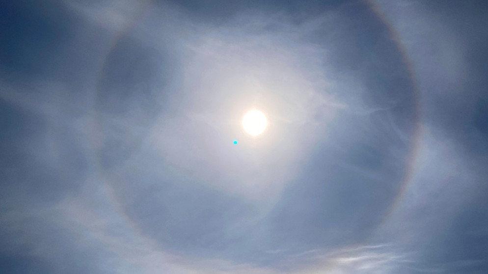 Am 14. April 2022 mittags hat Julia Fischer diesen großen Halo um die Sonne im Münchner Süden gesehen und ihn mit einem Smartphone fotografieren können. | Bild: Julia Fischer