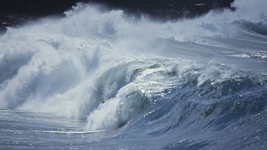 Brechende Wellen bei Ebbe und Flut: an den Gezeiten zeigt sich, welchen Einfluss der Mond auf die Erde hat.  | Bild: Getty Images
