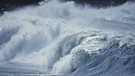 Brechende Wellen bei Ebbe und Flut: an den Gezeiten zeigt sich, welchen Einfluss der Mond auf die Erde hat.  | Bild: Getty Images