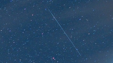 Eine Sternschnuppe aus dem Meteor-Strom der Perseiden, aufgenommen über den Schweizer Bergen. | Bild: picture-alliance/dpa