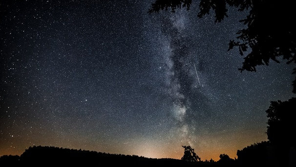 Eine einzelne Sternschnuppe vor der Milchstraße am Nachthimmel. | Bild: Jens Pohl