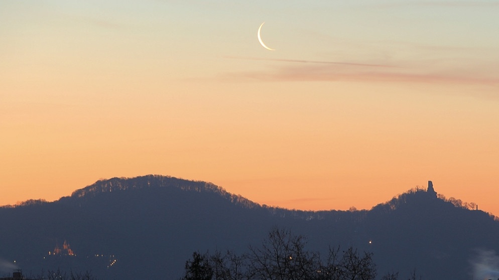Abnehmende, sehr dünne Mondsichel am frühen Morgen über dem Siebengebirge im Rheinland | Bild: Rüdiger Balhar
