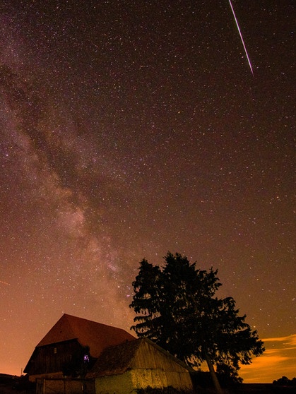 Ein Meteor des Perseiden-Sternschnuppen-Regens neben der Milchstraße am Sternenhimmel im August | Bild: Trix Pulfer